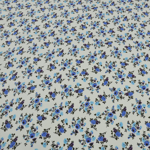 Скользкий синтетический трикотаж белого цвета с голубыми цветами